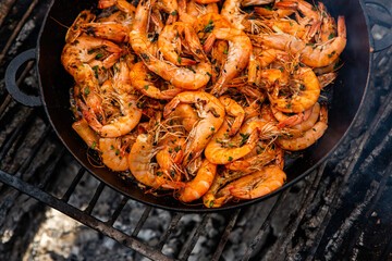 crispy fresh shrimp cooked on a frying pan in the wild. Rest in nature with fresh food
