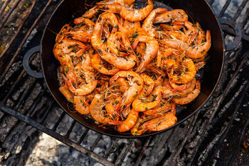 crispy fresh shrimp cooked on a frying pan in the wild. Rest in nature with fresh food
