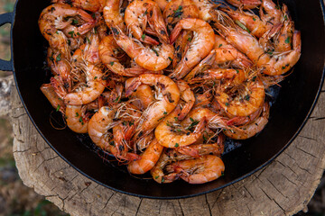 crispy fresh shrimp cooked on a frying pan in the wild. Rest in nature with fresh food
