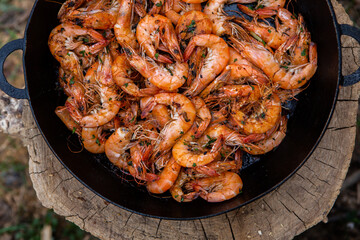 crispy fresh shrimp cooked on a frying pan in the wild. Rest in nature with fresh food
