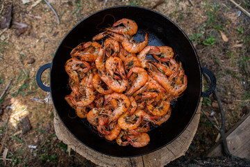 crispy fresh shrimp cooked on a frying pan in the wild. Rest in nature with fresh food
