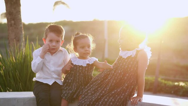 Ni&ntilde;os amigos hermanos felices alegres risue&ntilde;os conviviendo jugando disfrutando platicando en un bello atardecer cayendo el sol en el parque al aire libre