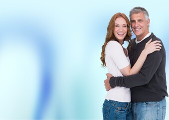 Fototapeta premium Portrait of caucasian senior couple hugging against copy space on blue gradient background