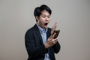 Excited happy, Surprised asian man saying wow and holding mobile phone and looking thrilled with event coming up, Concept Sales promotion shock price, free for copy blank space