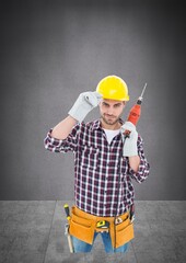 Portrait of caucasian male worker holding a drill machine against copy space on grey background