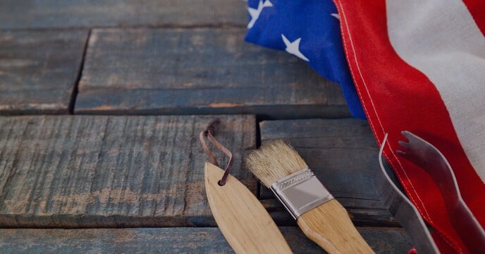 Close up of multiple tools and american flag on wooden surface