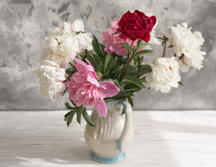 Still life with white and pink peonies in a white vase