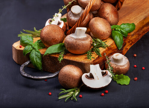 Fresh champignon mushrooms on dark wooden table