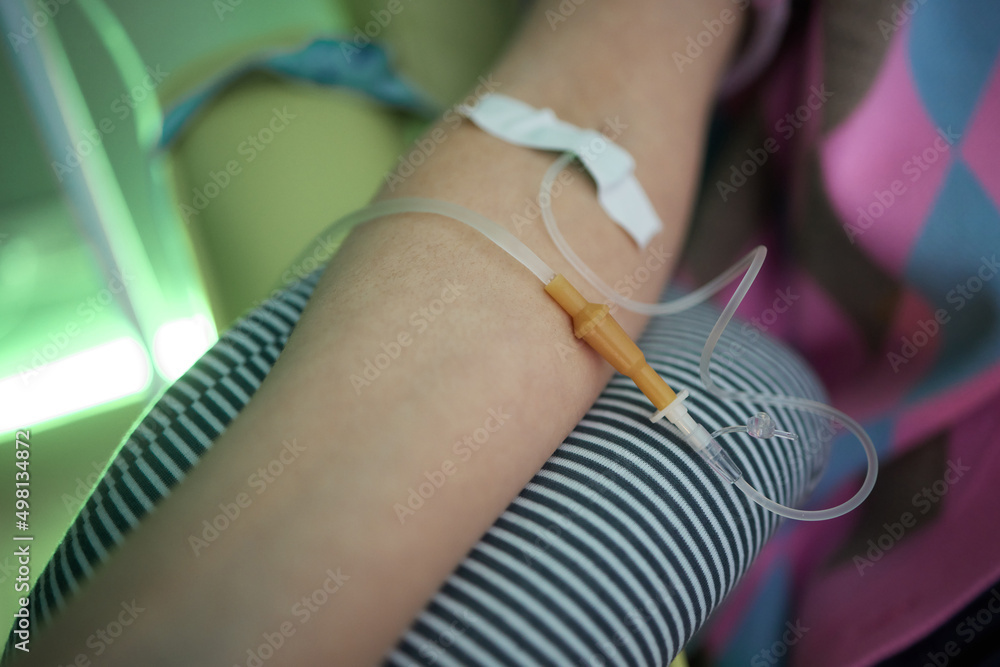 Wall mural Doctor drawing blood sample from arm for blood test, close-up. Phlebotomist technician drawing blood for testing Coronavirus COVID-19 disease infestation. Concept of healthcare and medicine.