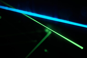 Bright green neon laser lights illuminate the darkness creating lines.