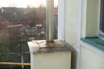 Old rusty iron chimney on the roof of a destroyed house.