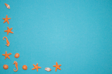 Turquoise background with seashells in the shape of starfish and seafood with empty space in the middle.