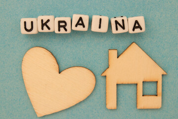 Napis Ukraina leżący nad drewnianym sercem i domem - symobliczne znaczenie - obrazy, fototapety, plakaty