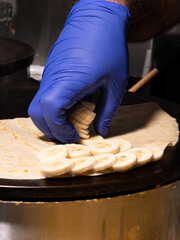 preparing banana crepe on hot plate 