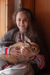 portrait of a girl in a Russian folk dress with a rabbit in her arms, Easter card