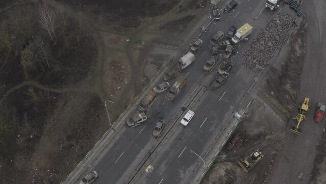Post-apocalypse. Destroyed bridge with burnt cars. War. Ukraine. Irpin. Aerial 