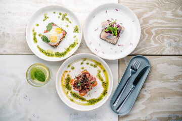 Smorrebrods, Danish open sandwich with salmon, egg, roast beef sweet onions, herring, onion, avocado and cilantro sauce.