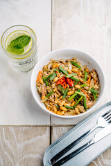 Asian rice noodles with chicken, mushrooms, peanuts, hot peppers, carrots and sesame seeds