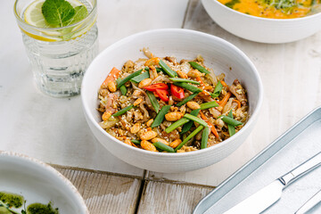 Asian rice noodles with chicken, mushrooms, peanuts, hot peppers, carrots and sesame seeds