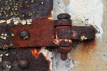 Red and orange rust cover an old hinge at the Sandy Hook Fort