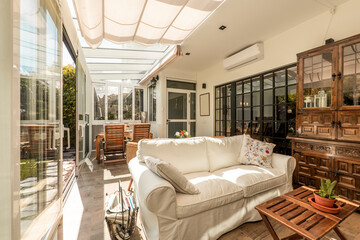 Interior of a white aluminum and glass closed terrace with large sliding doors with access to a...