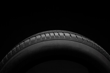 New car tire. Road wheel on dark background. Summer Tire with asymmetric tread design. Driving car...