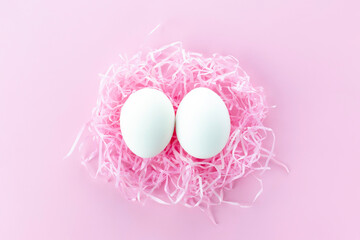 Easter background.Funny eggs in the nest. Postcard with space for text in pink, toned
