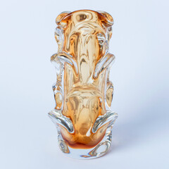 Old glass vase of yellow-orange color of an unusual shape. Retro style 60s, vintage. Decorative vase for flowers. Soft focus