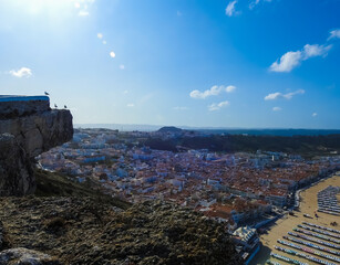 Beach landscape on a sunny day, with view to the city from a mountain. Nazare, Portugal