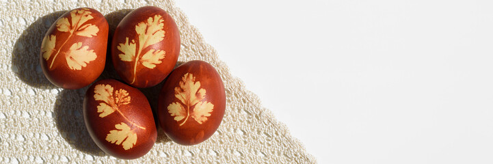 Panoramic photo. Top view of easter eggs, lying on lace tablecloth. Tradition and rustic arrangement. Easter concept. Copy space.