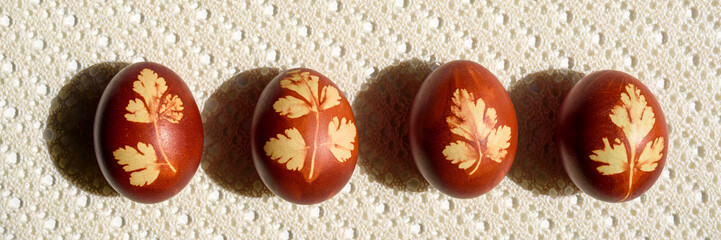 Panoramic photo. Top view of easter eggs, lying on lace tablecloth. Traditional and rustic arrangement. Easter concept.