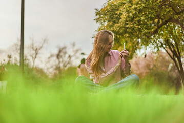Naklejka na ściany i meble Young white woman enjoying a view while making a photo in an urban park