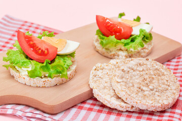Rice Cake Sandwiches with Tomato, Lettuce and Egg on Wooden Cutting Board. Easy Breakfast. Diet Food. Quick and Healthy Sandwiches. Crispbread with Tasty Filling. Healthy Dietary Snack