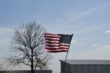 American Flag on by Barns in a Farm Field