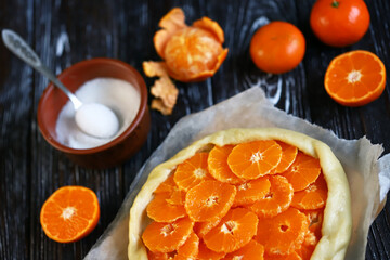 selective focus. Mandarin galette before baking. Cooking citrus galette.