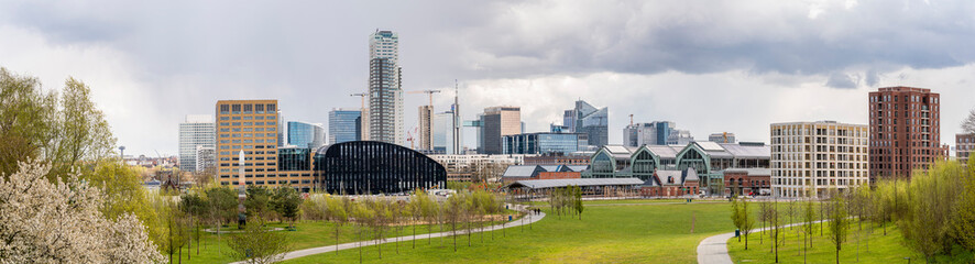 Fototapeta na wymiar Panoramic cityscape of Brussels city center and economic district with skyscrapers in spring on a sunny day with a dramatic sky and a green park in the foreground