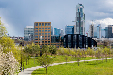 Panoramic cityscape of Brussels city center and economic district with skyscrapers in spring on a sunny day with a dramatic sky and a green park in the foreground