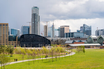 Panoramic cityscape of Brussels city center and economic district with skyscrapers in spring on a sunny day with a dramatic sky and a green park in the foreground