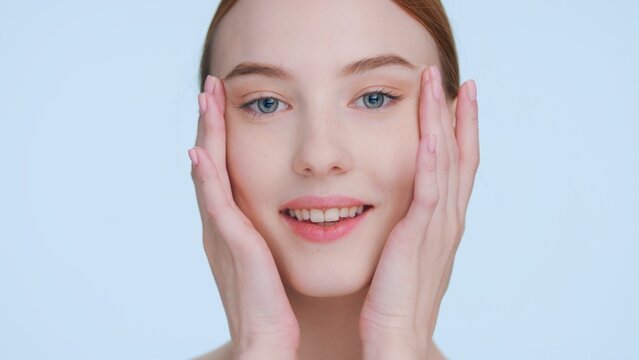 Young woman touches her face demonstrating skin elasticity