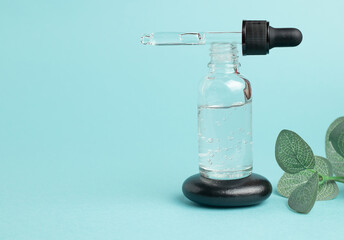Cosmetic mean for facial care. Pipette bottle on stone filled with essential oil, essence, serum for care of female skin