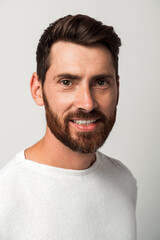 Obraz premium Bearded handsome man in casual style looking at the camera and smiling while posing