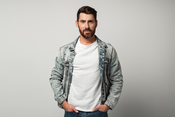 Obraz premium Bearded handsome man in casual style looking at the camera and smiling while posing