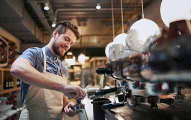 I found my lifes passion in a cup of coffee. Cropped shot of a handsome young man working in a cafe.