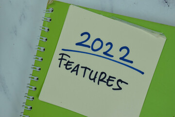 2022 Features write on sticky notes isolated on Wooden Table.