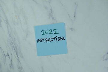 2022 Instructions write on sticky notes isolated on Wooden Table.