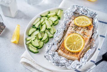 Salmon with herbs and lemon slices baked in a foil