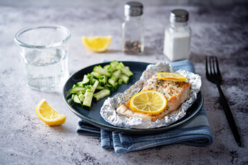 Salmon with herbs and lemon slices baked in a foil