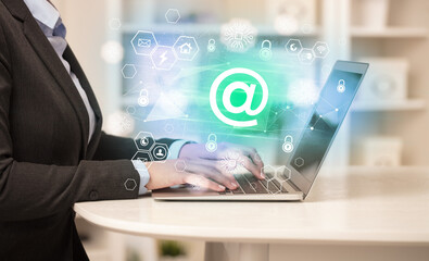 Hands working on laptop with digital icons concept