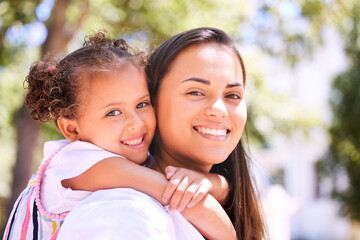 Lets go play mom. Shot of a mother giving her daughter a piggyback ride in the park.