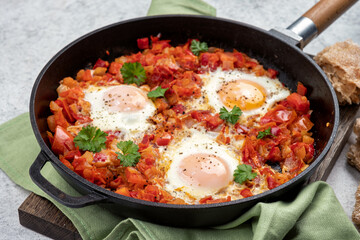 Shakshouka, eggs poached in sauce of tomatoes,